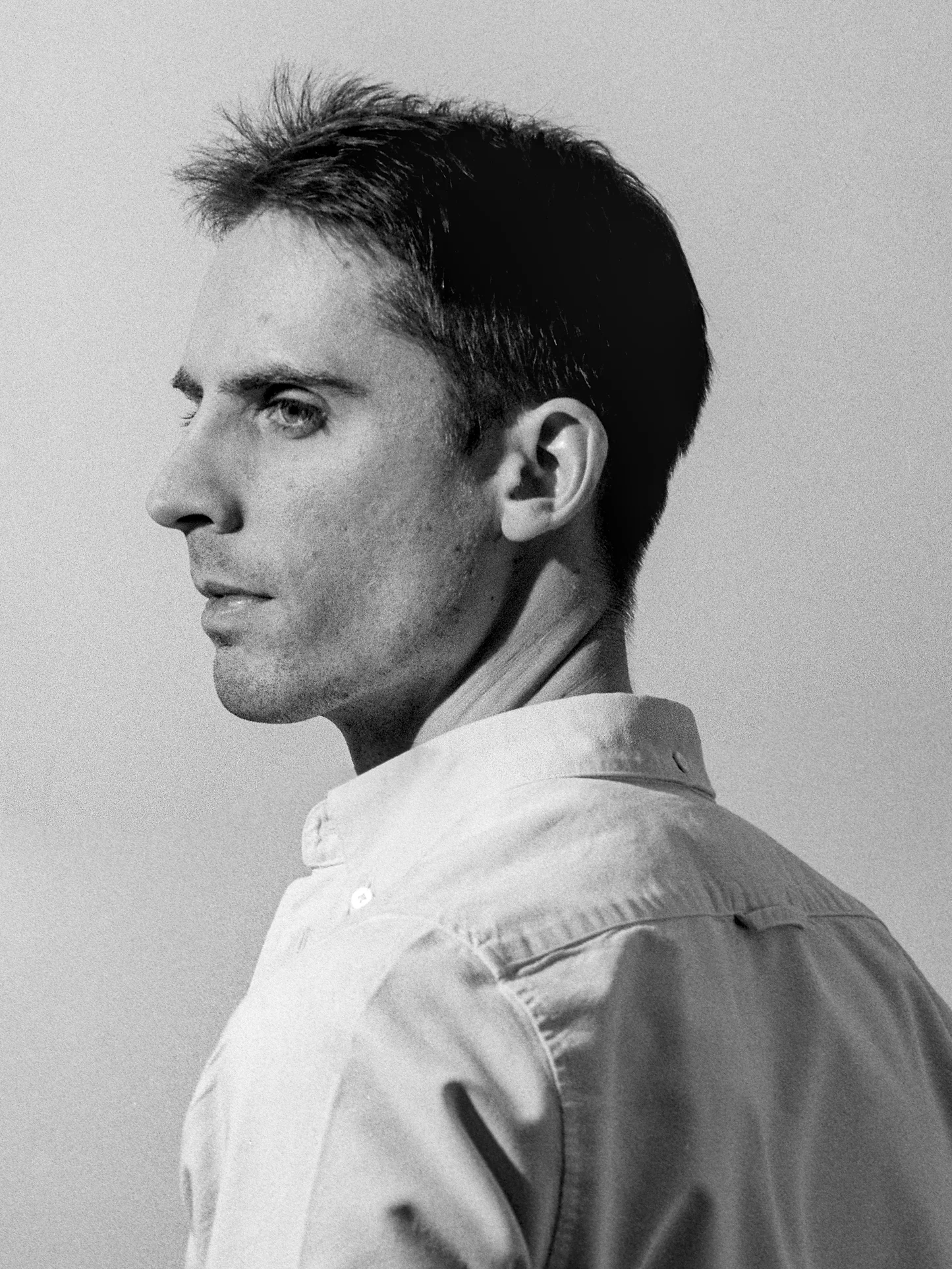 Portrait of a man in black and white, with his back turned toward the viewer.